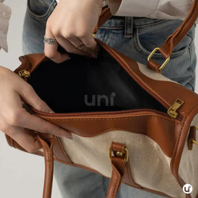 Bolsa de lona feminina Le Classique com alças de ombro e detalhes em couro sintético, com design elegante e versátil para o dia a dia e viagens curtas.